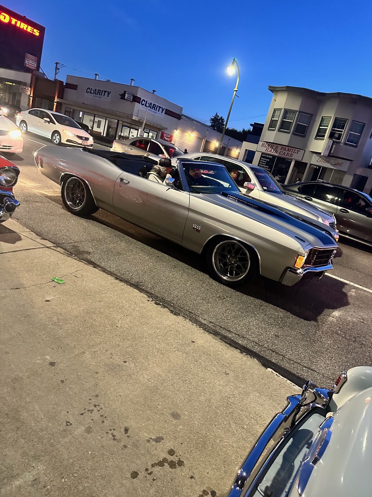 A silver Chevelle convertible driving down El Camino Real during the blue hour