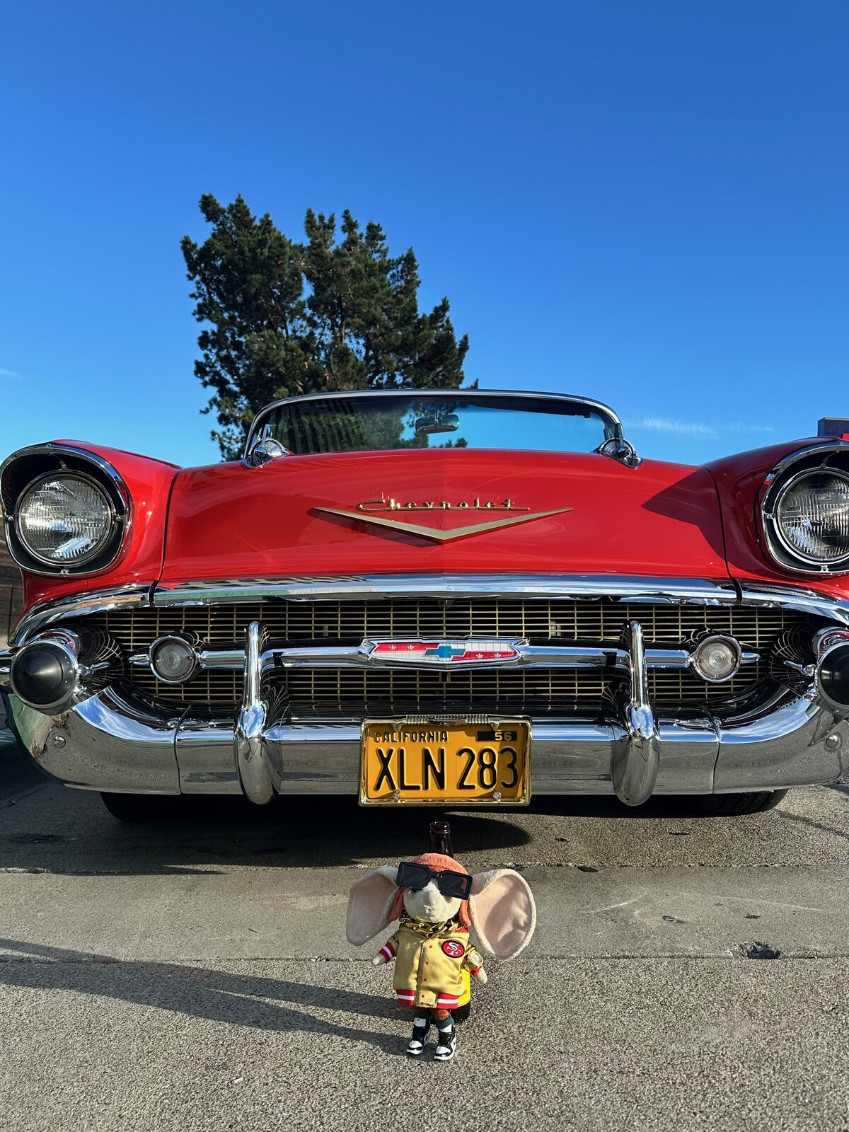A red 1957 Chevrolet Bel Air photographed head on against a clear blue sky